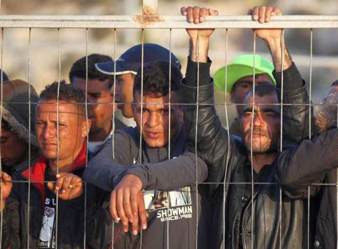 WCENTER 0XLDCHXHBL                Gli immigrati giÃ  sbarcati sull'isola di Lampedusa osservano dalle banchine i nuovi arrivi oggi 27 marzo 2011.  ANSA FILIPPO VENEZIA