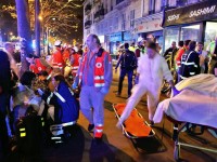 People rest on a bench after being evacuated from the Bataclan theater after a shooting in Paris, Saturday, Nov. 14, 2015. A series of attacks targeting young concert-goers, soccer fans and Parisians enjoying a Friday night out at popular nightspots killed over 100 people in the deadliest violence to strike France since World War II. (ANSA/AP Photo/Thibault Camus)