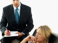 young woman lying on a sofa with a male psychiatrist taking notes