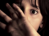 MODEL RELEASED. Child abuse. Nine year old boy cowering behind his hands from an attacker.