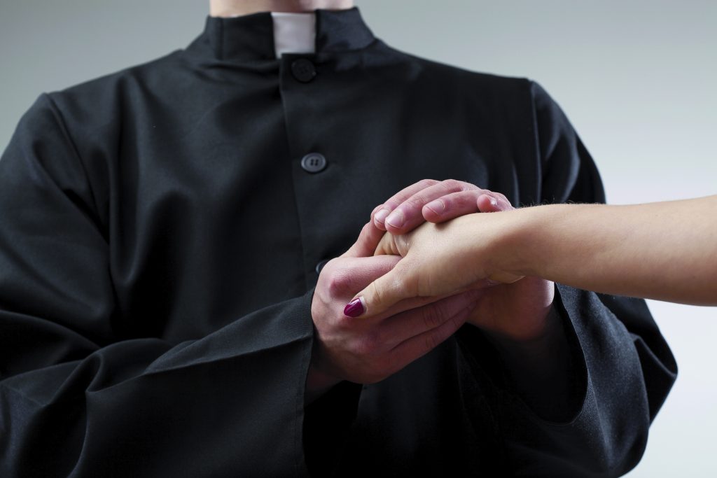 Priest holding believer hand