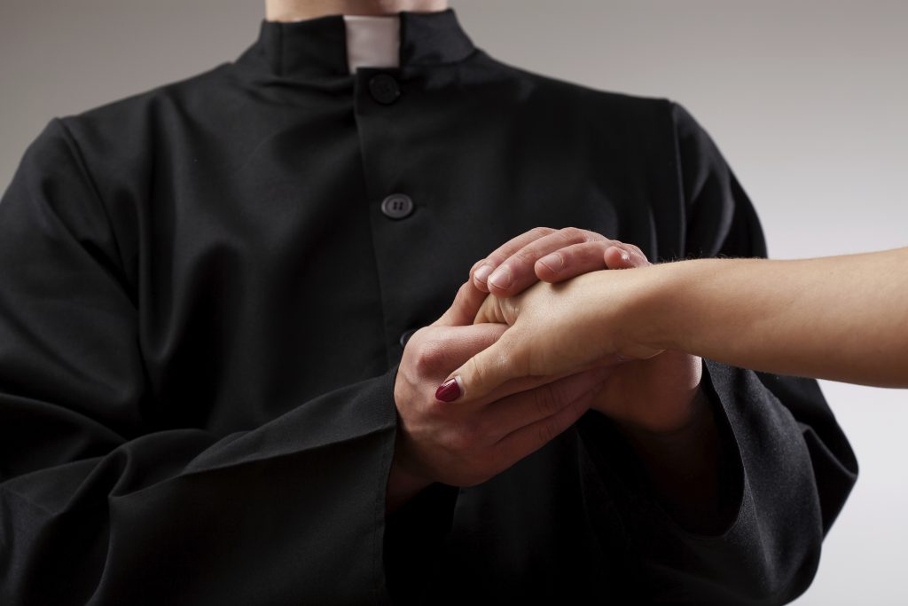 Priest holding believer hand