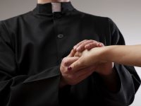 Priest holding believer hand