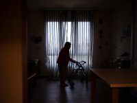 An elderly resident stands helped by a walker in a common area at the 'Torre della Rocchetta' retirement home in Albuzzano, near Pavia, Northern Italy, on November 3, 2020. (Photo by Marco Bertorello / AFP)
