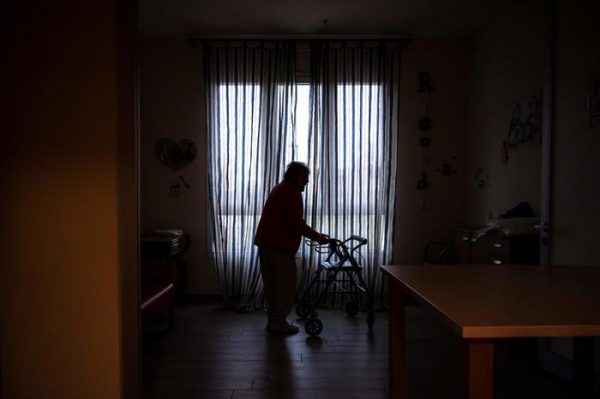An elderly resident stands helped by a walker in a common area at the 'Torre della Rocchetta' retirement home in Albuzzano, near Pavia, Northern Italy, on November 3, 2020. (Photo by Marco Bertorello / AFP)