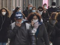People wearing protective face mask walk and shop in the center of Milan, Italy, 25 January 2021. In Italy, the orange zones (medium-high risk) , as the Lombardy Region, stipulates that shops can open, while restaurants and bars are closed except for takeaway. ANSA/DANIEL DAL ZENNARO