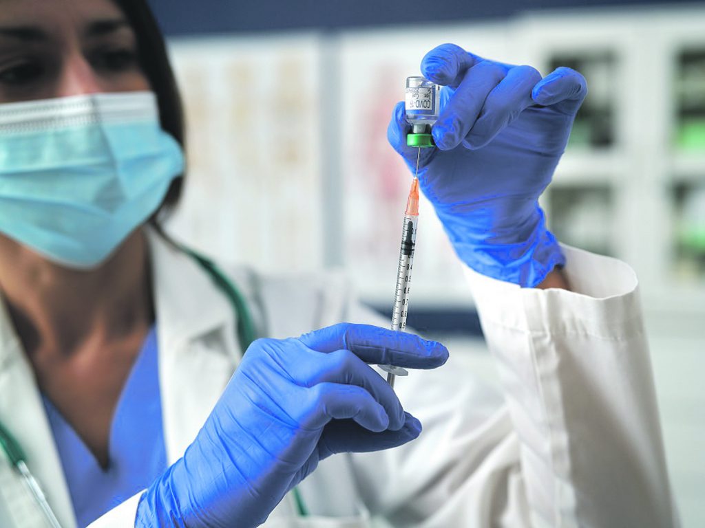 Doctor with syringe and vaccine for COVID-19