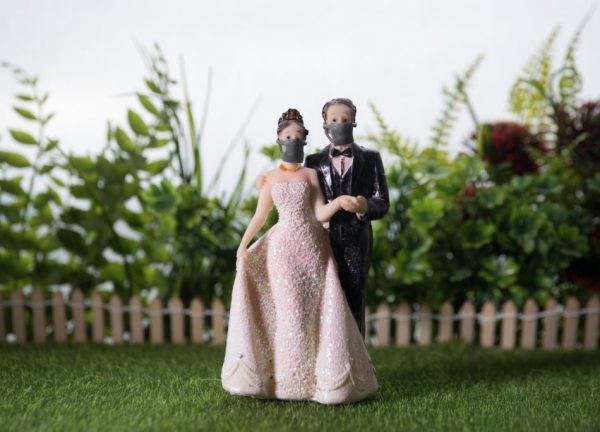 Miniature people : Happy bride wearing masks to protect against viruses during wedding time. People wear masks to prevent New type COVID-19 pneumonia. Coronavirus and Covid-19 concept. Selective focus