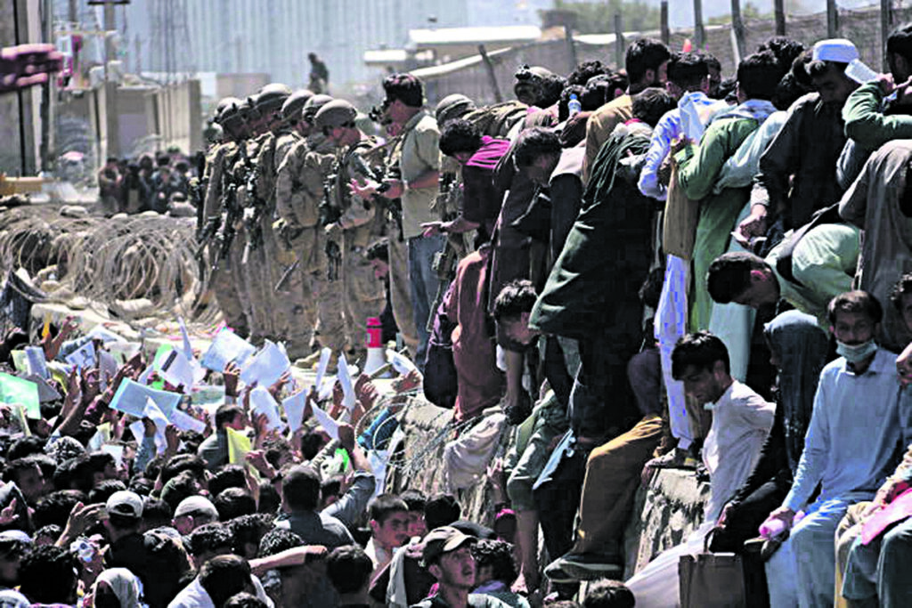 epa09430527 Afghans struggle to reach the foreign forces to show their credentials to flee the country outside the Hamid Karzai International Airport, in Kabul, Afghanistan, 26 August 2021. At least 13 people including children were killed in a blast outside the airport on 26 August. The blast occurred outside the Abbey Gate and follows recent security warnings of attacks ahead of the 31 August deadline for US troops withdrawal. EPA/AKHTER GULFAM