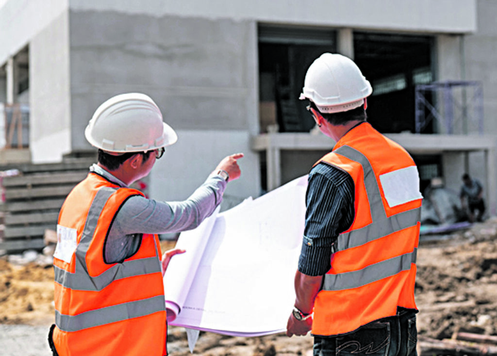 Construction engineers discussion with architects at construction site