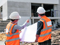 Construction engineers discussion with architects at construction site
