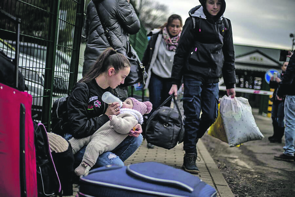 epaselect epa09783747 A woman feeds a child as people fleeing Ukraine arrive in Slovakia through the Ubla border crossing, 25 February 2022. Slovakia said it will let fleeing Ukrainians into the country following Russia's military operation in Ukraine. The Slovak Police Force announced on social media that people not holding a valid travel document will also be eligible for entry on an individual basis.  EPA/MARTIN DIVISEK