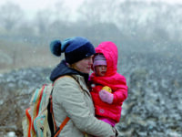 epa09807501 A Ukrainian mother holds her baby as she passes through the border crossing of Siret, northern Romania, 07 March 2022. Since Russia began its military operation in Ukraine on 24 February, some 261,445 Ukrainian citizen have entered Romania, according to the latest report of the Border Police.  EPA/ROBERT GHEMENT