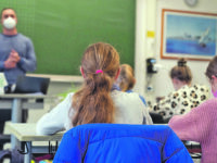 08.11.2021, Bayern, Würzburg: Schülerinnen und Schüler der Klasse 5c des Matthias-Grünewald-Gymnasiums in Würzburg sitzen mit Mund-Nasen-Schutz im Klassenzimmer. In Bayern beginnt die Schule nach den Herbstferien mit neuen Corona-Regeln. Foto: Nicolas Armer/dpa - ACHTUNG: Nur zur redaktionellen Verwendung im Zusammenhang mit der aktuellen Berichterstattung über den ersten Schultag nach den Herbstferien in Bayern. +++ dpa-Bildfunk +++