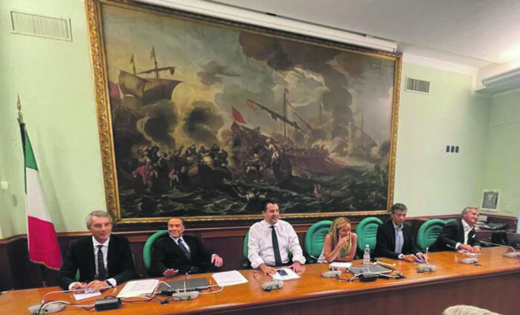 Silvio Berlusconi, Matteo Salvini e Giorgia Meloni seduti accanto e sorridenti sotto la mega tela della Battaglia di Lepanto che campeggia nella sala Salvadori di Montecitorio, 27 luglio 2022. E' un'immagine dei leader del centrodestra diffusa dallo staff della Lega durante il vertice della coalizione riunita in versione allargata in vista delle prossime elezioni, e ospitata negli spazi della Lega alla Camera.   ANSA / Ufficio stampa Lega  +++ ANSA PROVIDES ACCESS TO THIS HANDOUT PHOTO TO BE USED SOLELY TO ILLUSTRATE NEWS REPORTING OR COMMENTARY ON THE FACTS OR EVENTS DEPICTED IN THIS IMAGE; NO ARCHIVING; NO LICENSING +++