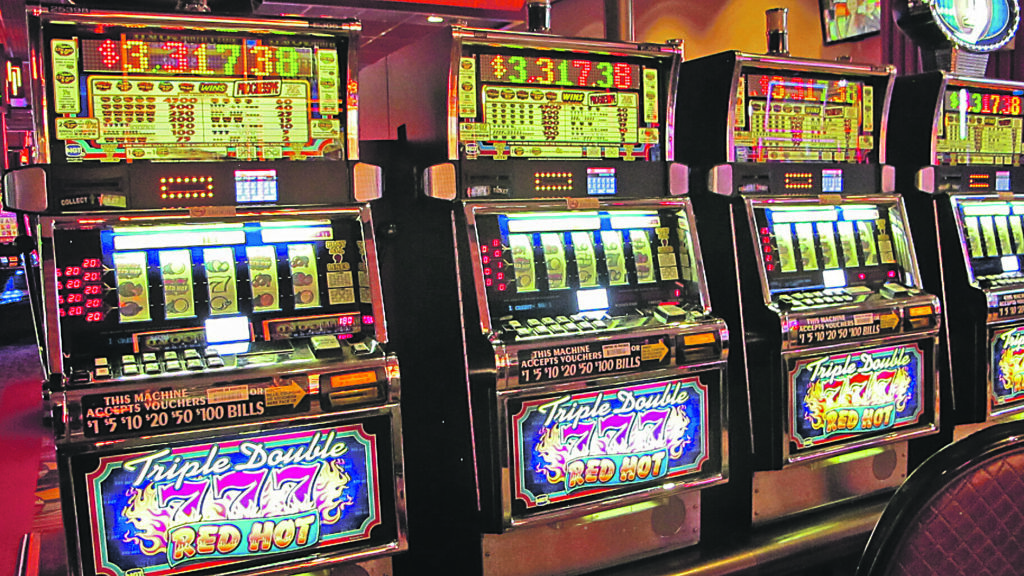 In this June 23, 2021 photo, a row of slot machines sit empty at Bally's casino in Atlantic City N.J. A gambling technology company and a virtual mental health clinic announced Wednesday, July 7, 2021, that they are joining with New Jersey's Rutgers University to study the effectiveness of compulsive gambling and video game-playing treatments that are offered in a virtual setting. (AP Photo/Wayne Parry)